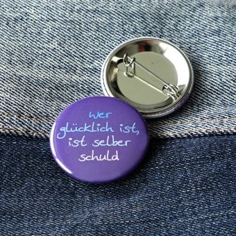 Ansteckbutton Wer glücklich ist, selber schuld auf Jeans mit Rückseite